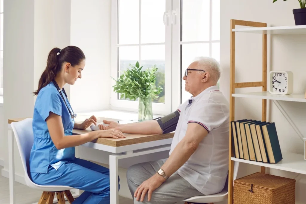 Nurse with elderly patient taking blood pressure