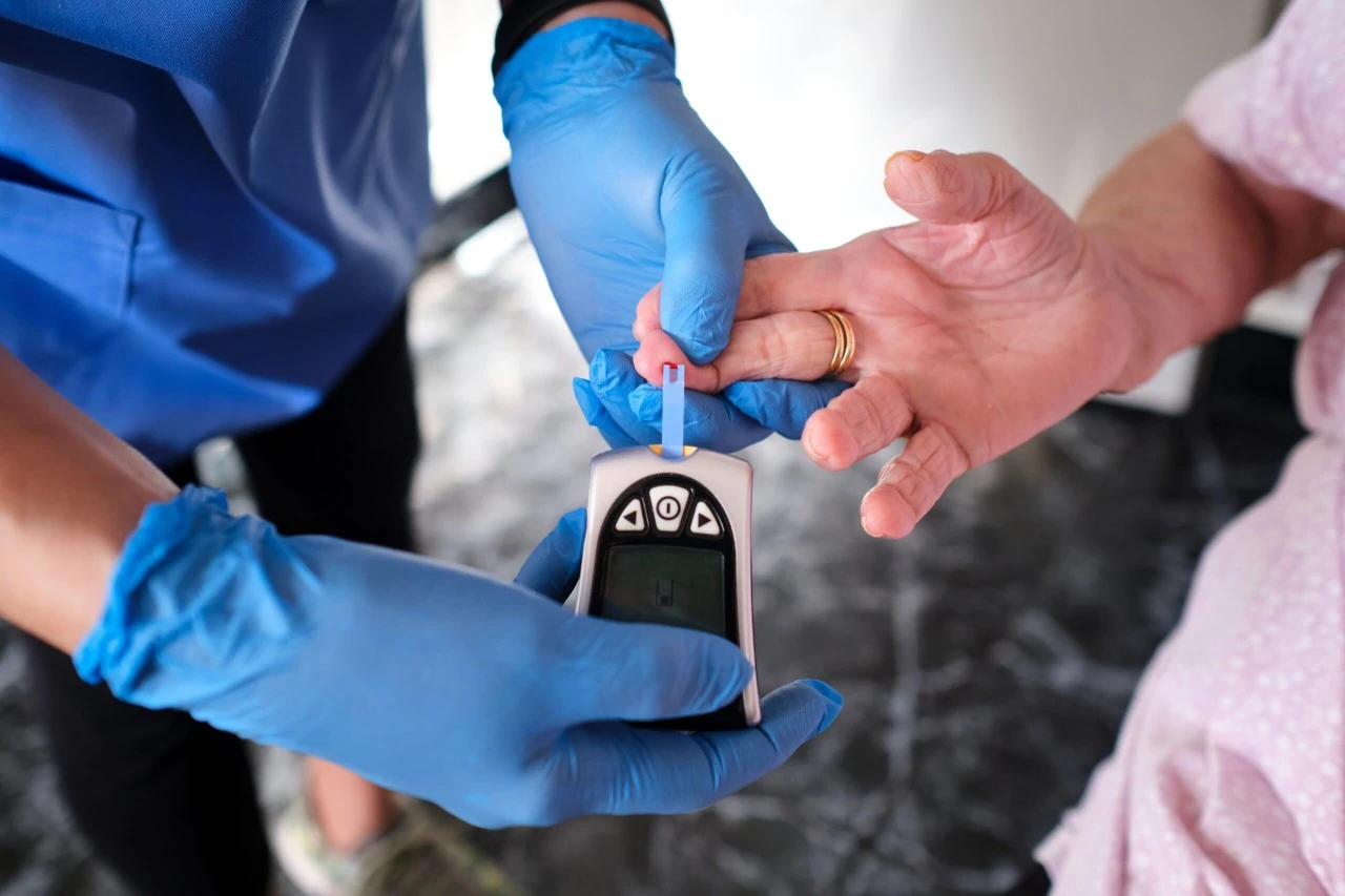 Blood sugar level check by nurse on patient