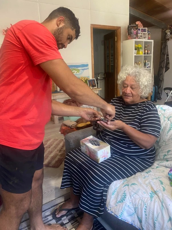 Man helping woman on couch in home