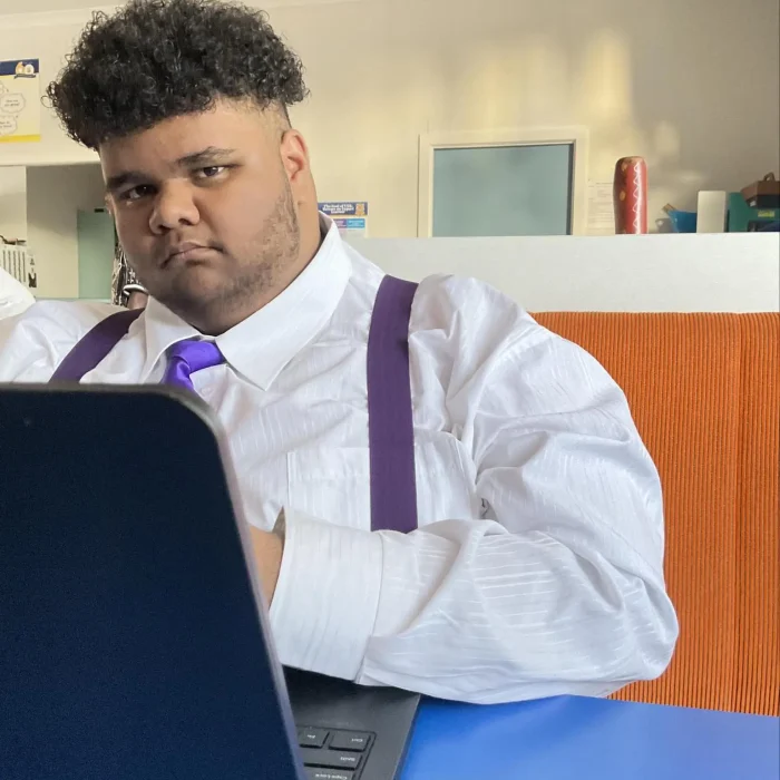 Aboriginal man looking at camera with laptop