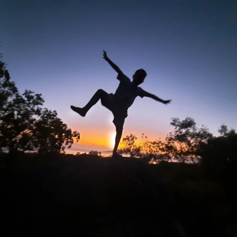 At dusk, shadow of boy dancing against the sunset